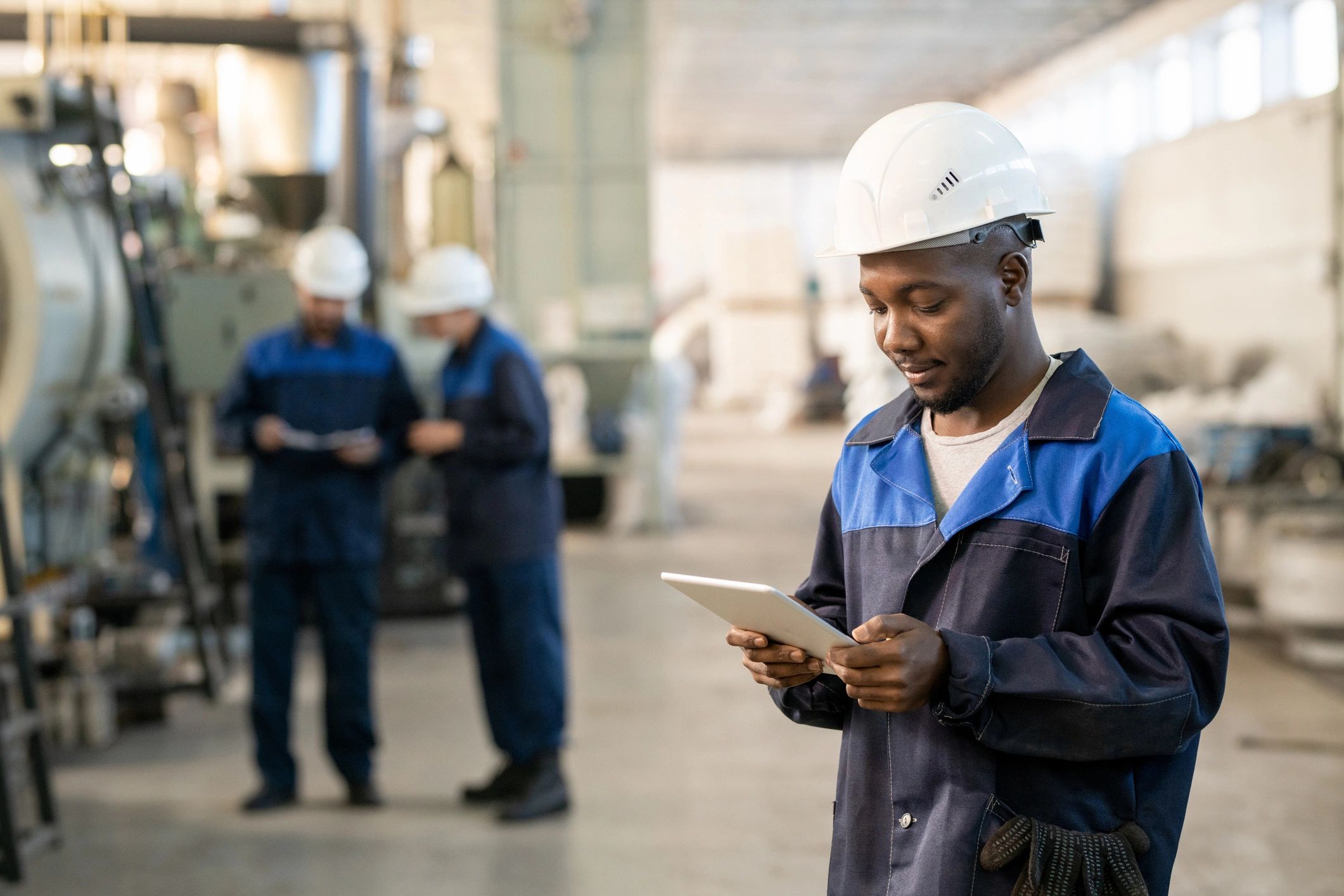 Factory worker using a digital tablet wearing safety gear