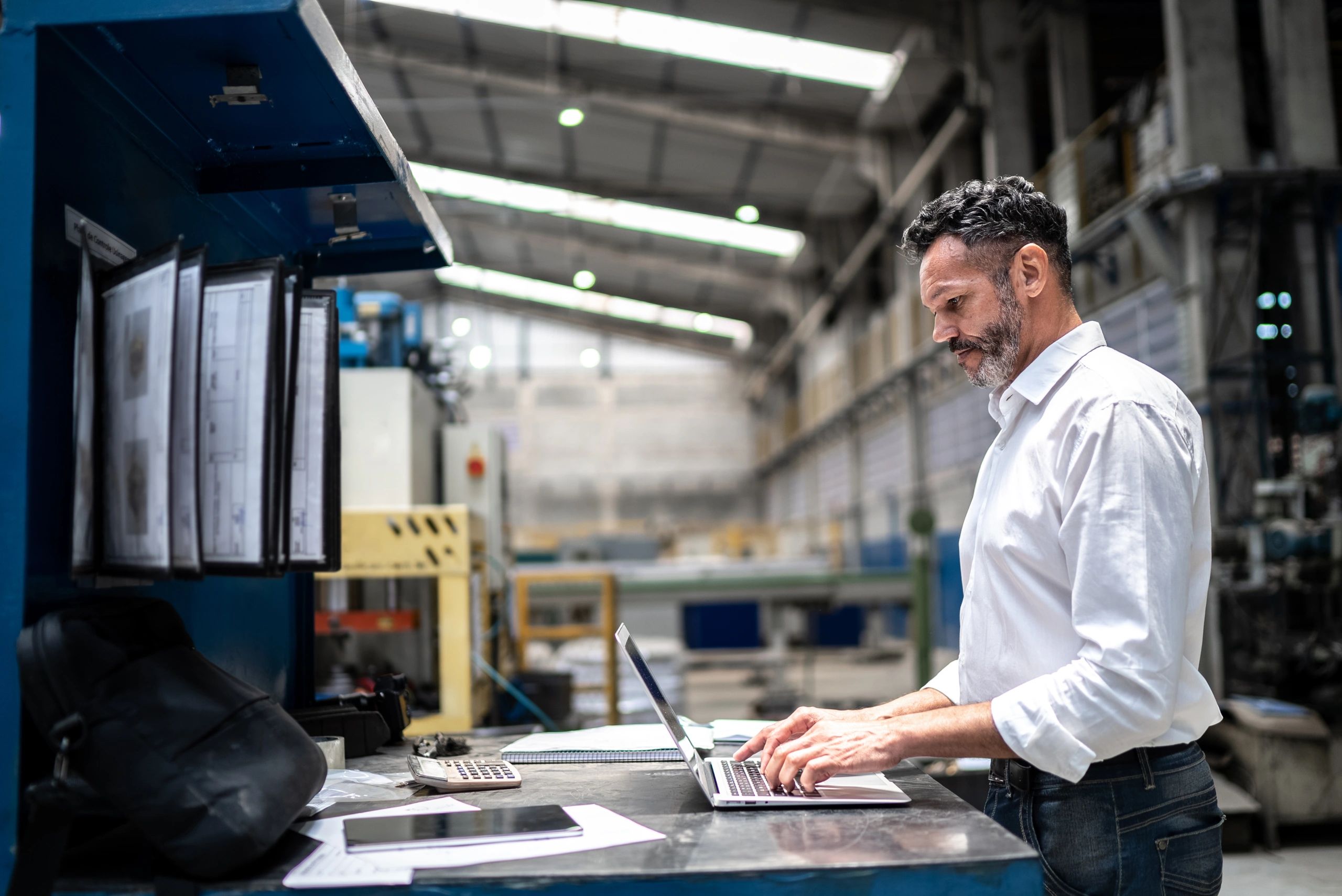 Manufacturing leader using a laptop on the factory floor