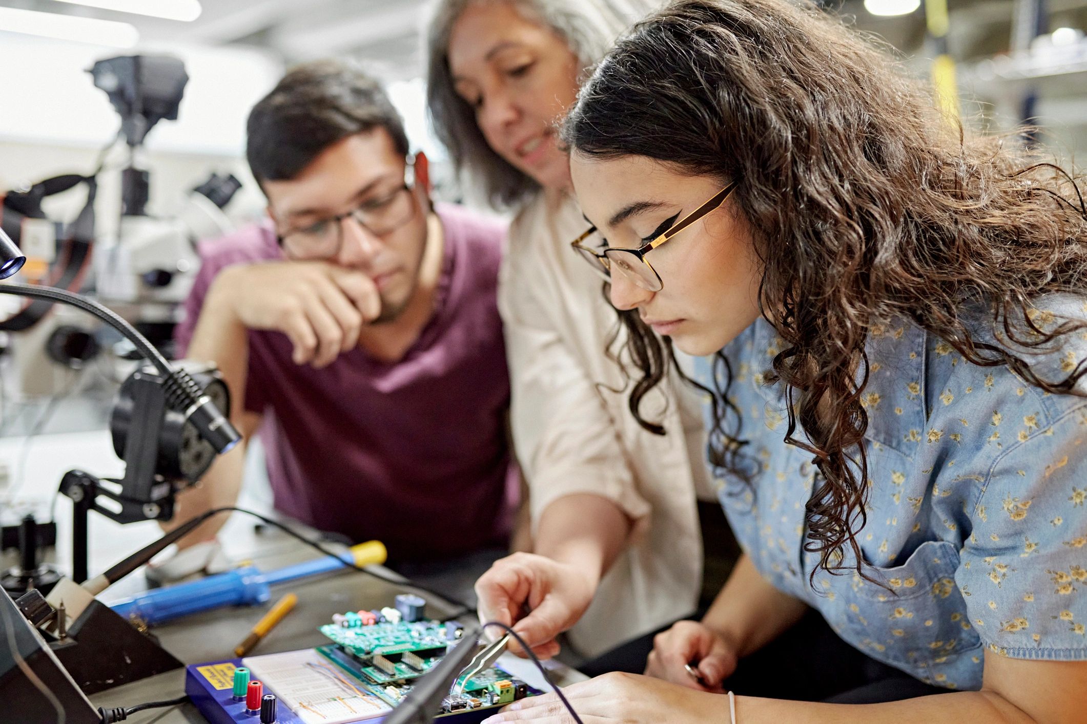 Instructor assisting engineering students on a project