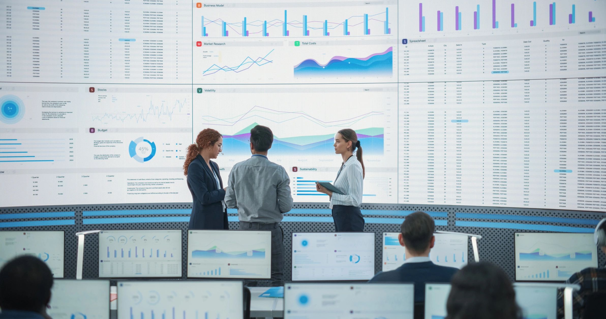 Operations team monitoring analytics on large screens in a control room