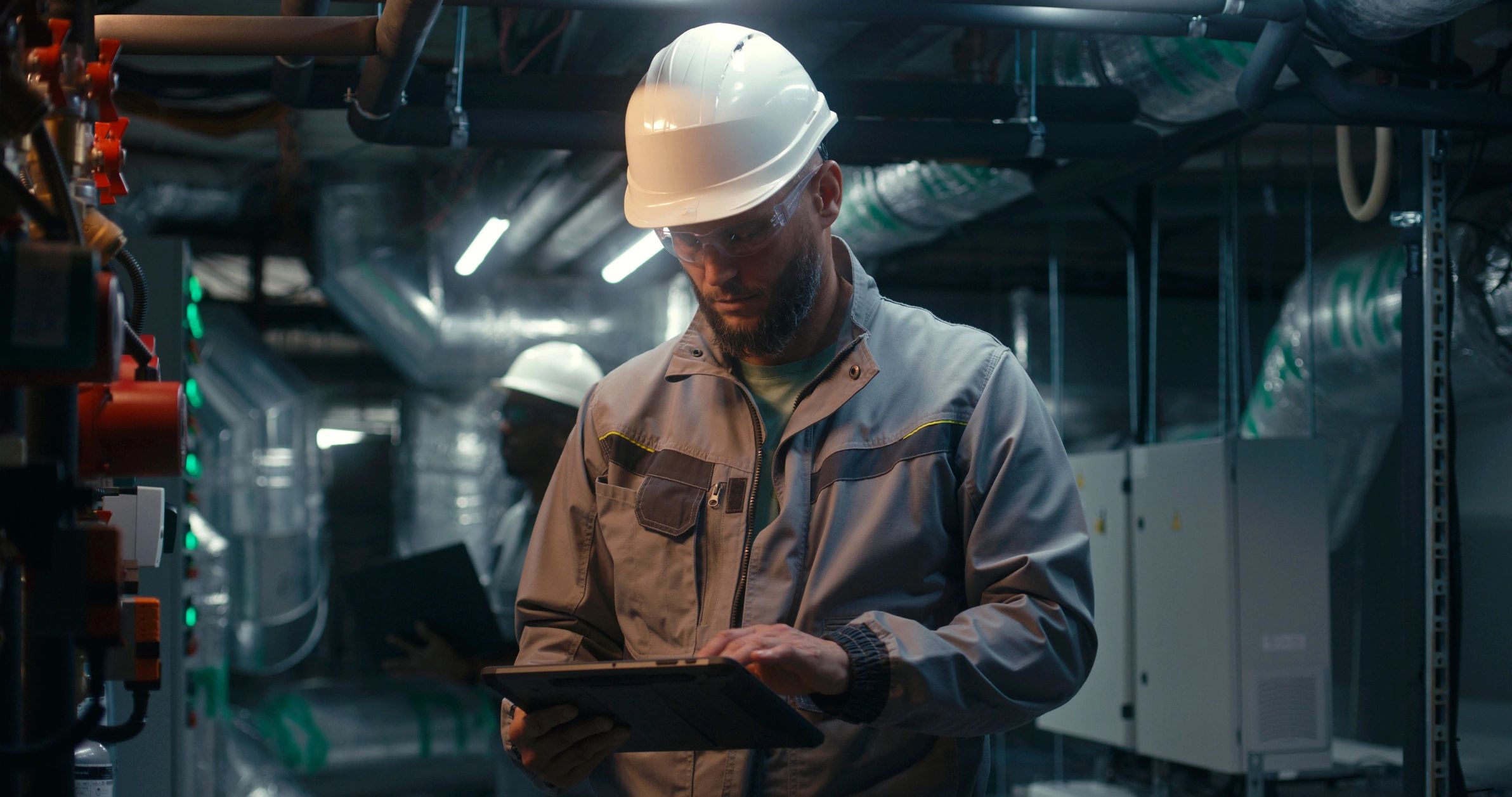 Industrial specialists using laptop and tablet in a plant